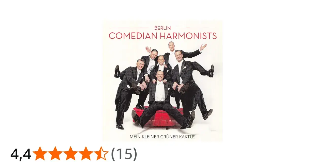 Comedian Harmonists in Anzügen posieren fröhlich auf einem roten Podest.