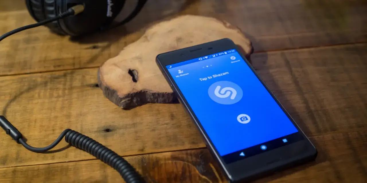 Kopfhörer und Smartphone mit Shazam-App. Wer singt dieses Lied? Shazam hilft, es herauszufinden.