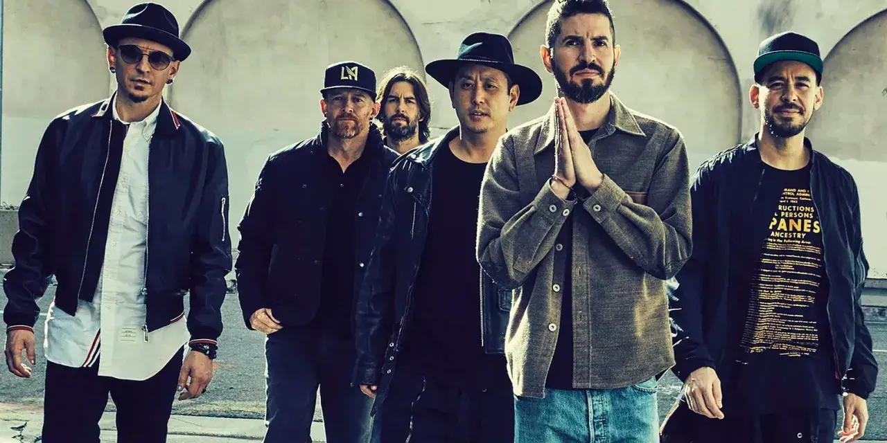 Sechs Männer der Band Linkin Park stehen nebeneinander, einige tragen Hüte und Jacken.