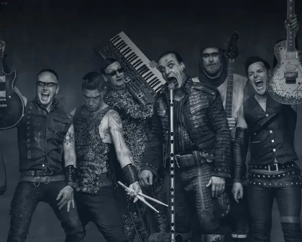 Rammstein-Bandmitglieder mit Instrumenten, schwarz-weiß.