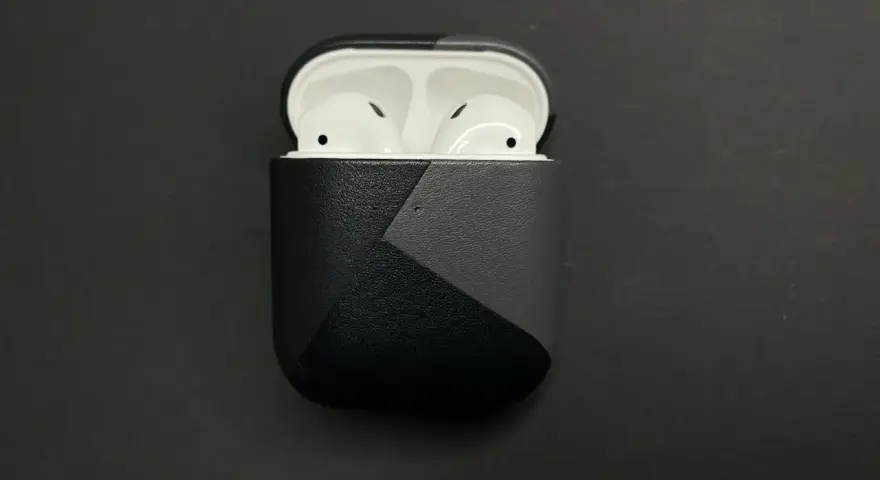 AirPods in einer schwarzen Hülle mit grauem geometrischem Muster.